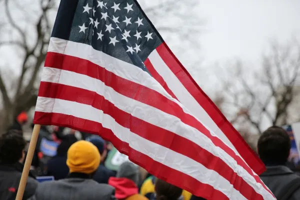 An image of a flag in front of a protester